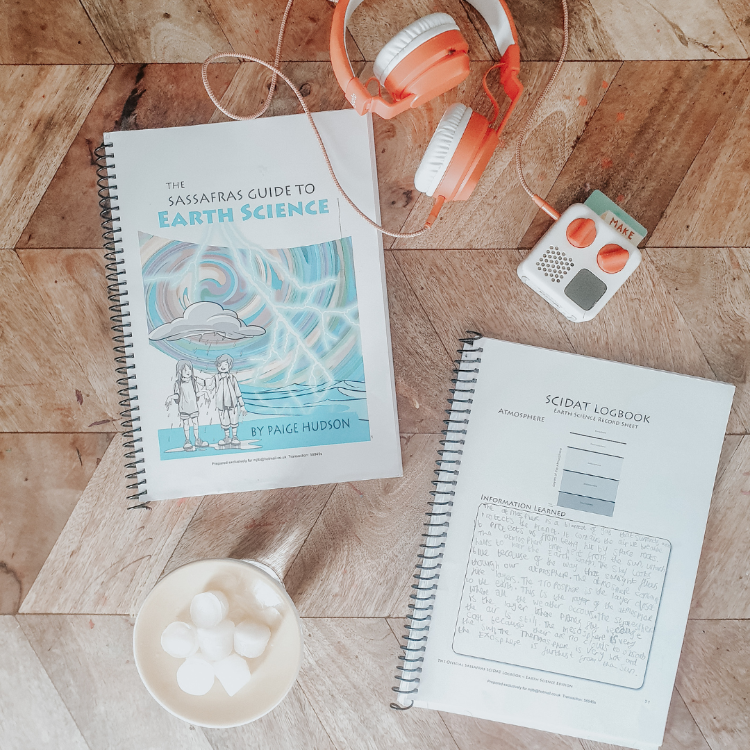 A homeschool science curriculum sits on a table, with a bowl of ice, some headphones and an audiobook player